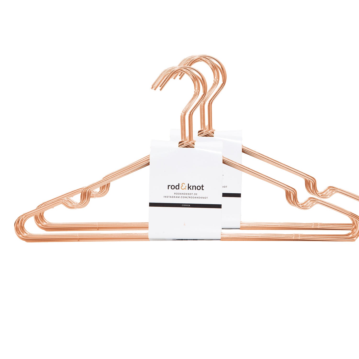 Ein Bündel aus vier metallischen Kleiderbügeln in Roségold mit modernem, eckigem Design, ordentlich gesichert mit einem Papieretikett mit dem Markennamen „rod & knot“. Diese Kleiderbügel aus stabilem Metall sind ideal zum Ordnen von Kleidung und zur platzsparenden Aufbewahrung.